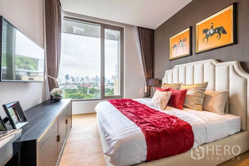 Condominium for rent or sale in Bang Rak, Bangkok - Bedroom with upholstered headboard, framed art and expansive window framing the city.