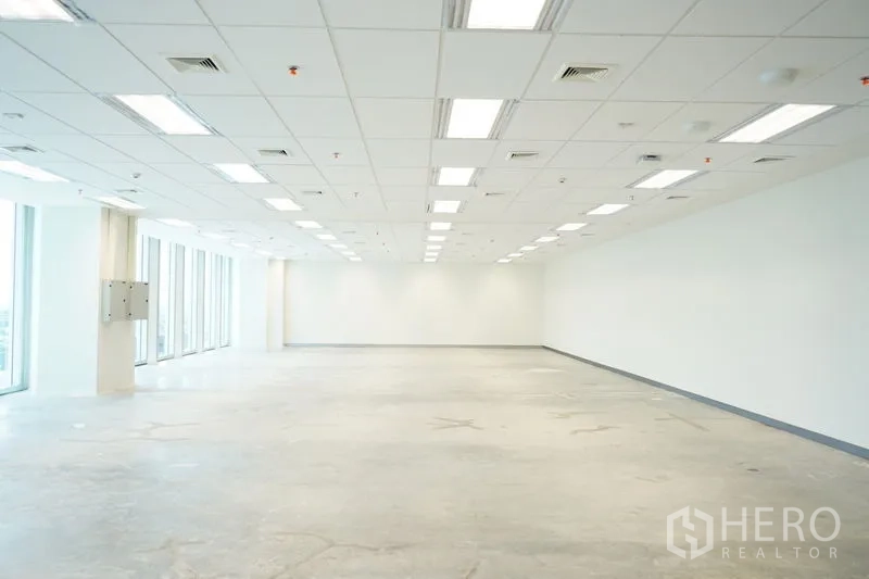 Office Space for rent in Bang Na, Bangkok - Spacious white‑box office with wide column‑free area beside tall windows.