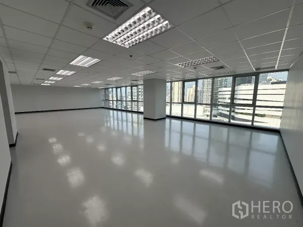 办公空间 出租在Watthana, Bangkok - 高楼层开放式办公室，整面玻璃窗与曼谷天际线景观，栅格吊顶与明亮灯光。