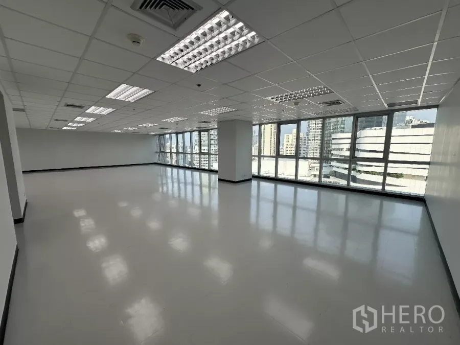 办公空间 出租在Watthana, Bangkok - 高楼层开放式办公室，整面玻璃窗与曼谷天际线景观，栅格吊顶与明亮灯光。