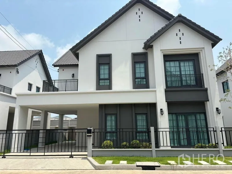 Detached House for rent in Bang Phli, Samut Prakan - Modern two-storey detached house with gabled roof, black metal fence, covered carport and a small front lawn in Bang Phli.