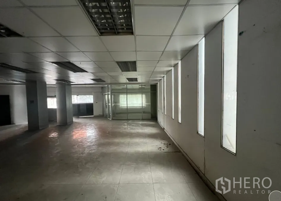 Shophouse for rent or sale in Khlong Toei, Bangkok - Open-plan floor with tall narrow windows bringing natural light into the space.