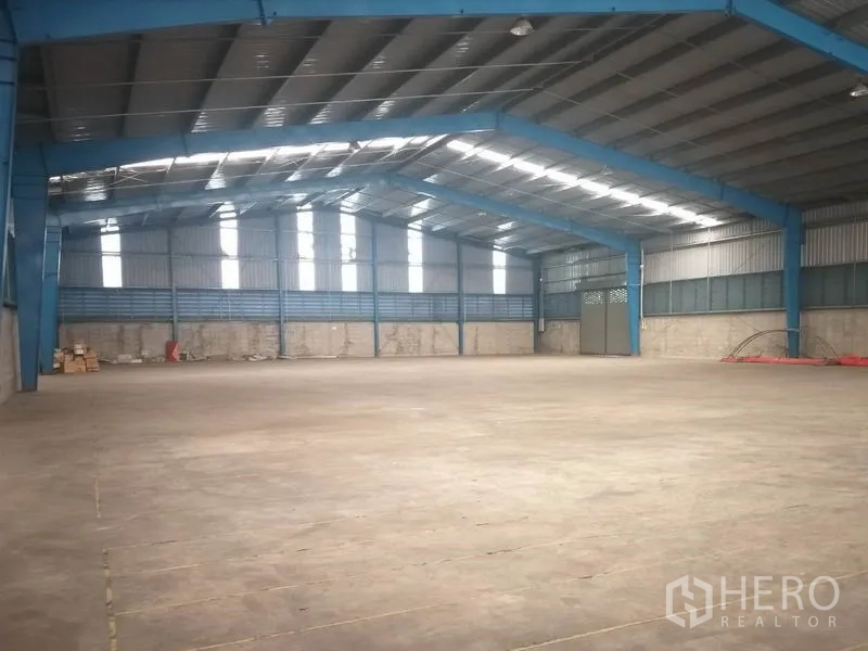 货栈 出租在Pathum Thani - 开阔无柱空间，蓝色钢柱与通风侧墙