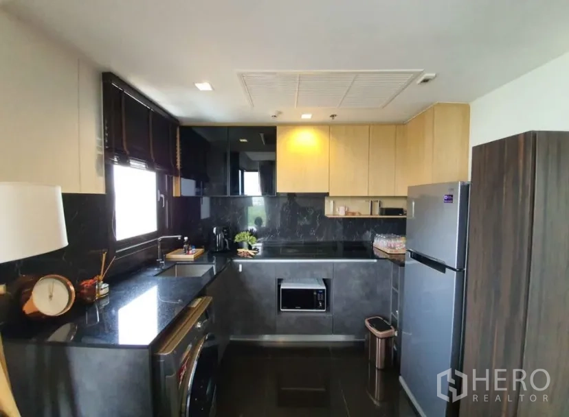 คอนโด for rent in Chatuchak, Bangkok - ห้องครัวสมัยใหม่ท็อปหินสีเข้ม พร้อมตู้เก็บของและตู้เย็นสเตนเลส