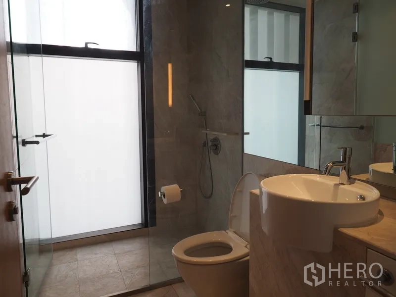 Condominium for rent in Sathon, Bangkok - Sleek bathroom with walk-in shower, frosted window and modern fixtures.