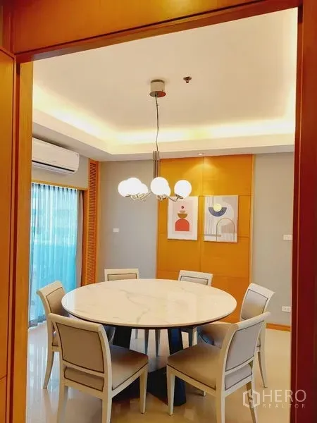 Apartment for rent - Bright dining room with a round marble-top table, six chairs, and a modern pendant light.