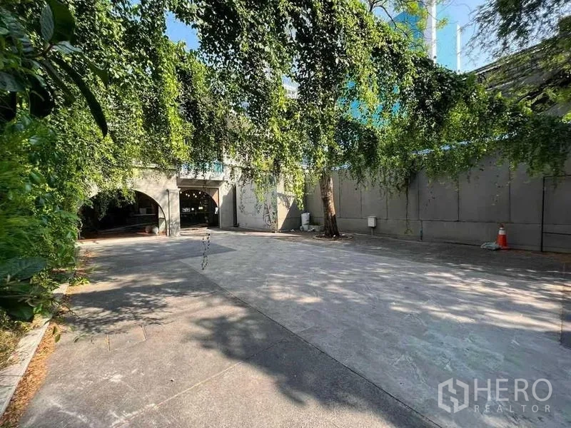 零售空间 出租在Phaya Thai, Bangkok - 庭院望向拱形立面，枝叶垂挂