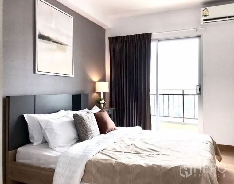 公寓 出租或出售在Huai Khwang, Bangkok - 卧室连通阳台，灰色强调墙、遮光窗帘与柔和灯光。