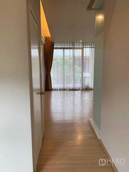 ทาวน์เฮาส์ ให้เช่าในKhan Na Yao, Bangkok - โถงทางเดินพื้นลามิเนตเชื่อมสู่ห้องขนาดใหญ่พร้อมหน้าต่างและผ้าม่าน