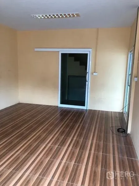 货栈 出租在Pak Kret, Nonthaburi - 一层办公室，木纹地砖与推拉玻璃门。