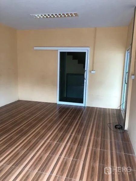 货栈 出租在Pak Kret, Nonthaburi - 一层办公室，木纹地砖与推拉玻璃门。
