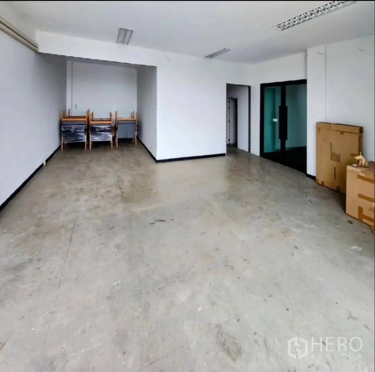 Factory for rent in Samut Prakan - Ground-floor office or showroom space with concrete floor and fluorescent lighting.