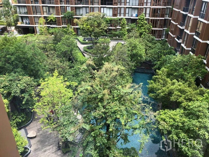 公寓 出租在Watthana, Bangkok - 俯视中庭，成熟大树、木栈道与自由形泳池。