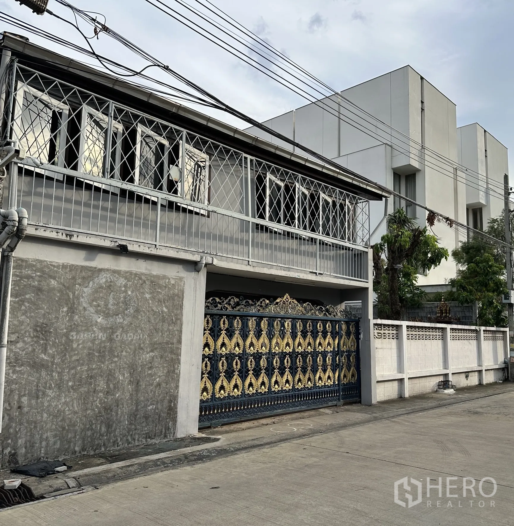 家庭办公室 for rent in Suan Luang, Bangkok - 侧立面可见蓝金色铁艺大门与窗户防护栏。