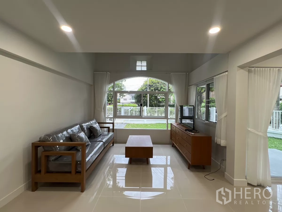Detached House for rent in Saphan Sung, Bangkok - Cozy living corner with sofa set facing a TV unit and arched front window.