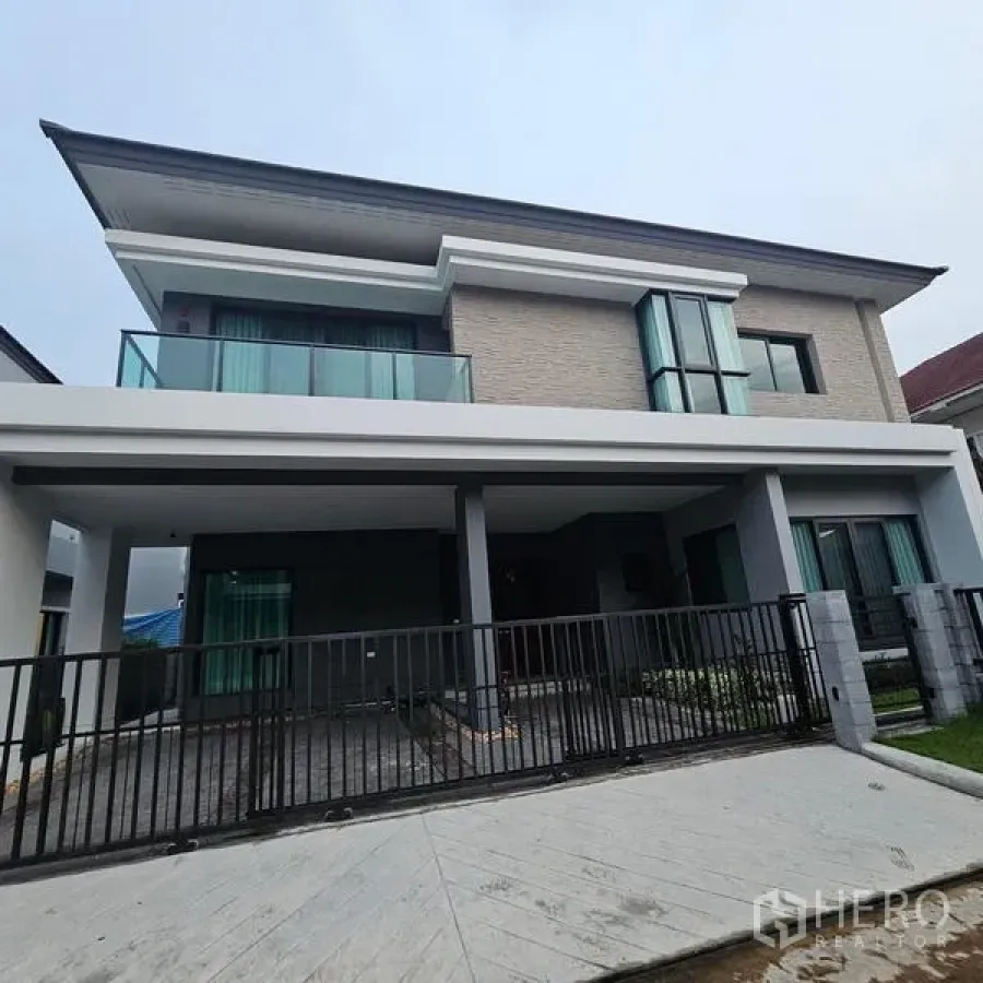 Detached House for rent in Saphan Sung, Bangkok - Front facade of the two-storey detached house with balcony and covered parking.