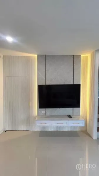 Townhouse for rent in Bang Phli, Samut Prakan - Living room media wall with built-in cabinet, accent lighting and glossy floor.