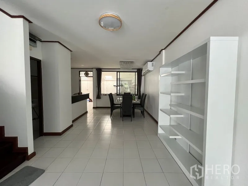 联排别墅 出租在Din Daeng, Bangkok - 开放式客餐厅，白色地砖、楼梯与内置置物架。