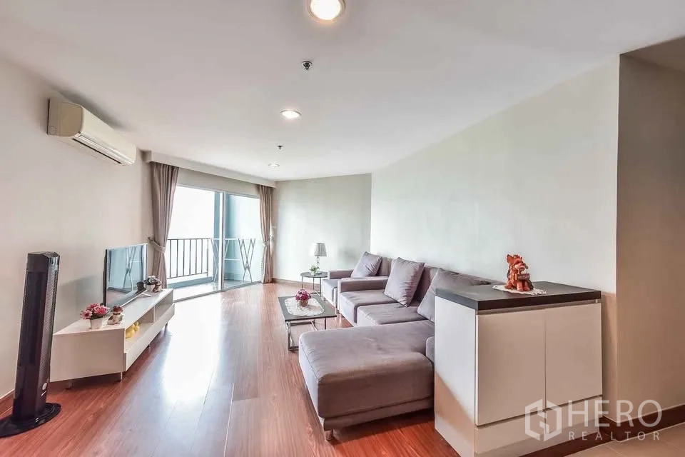 คอนโด for rent in Huai Khwang, Bangkok - พื้นที่นั่งเล่นเปิดออกสู่ระเบียงผ่านประตูกระจกบานเลื่อน