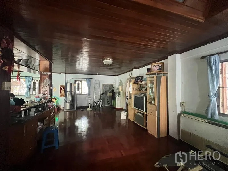 独立式住宅 出售在Phra Khanong, Bangkok - 宽敞客厅，木质天花与地板，设窗户与电视柜。