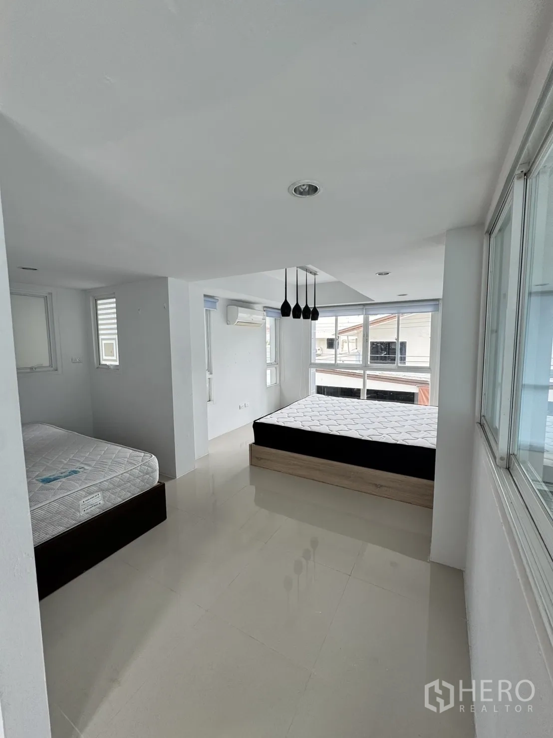 โฮมออฟฟิศ for rent in Watthana, Bangkok - ห้องนอนกว้าง มีเตียงสองเตียง ไฟแขวน และหน้าต่างมุมรับแสง