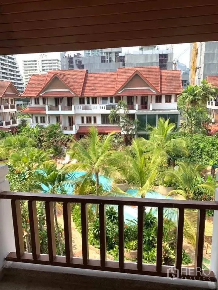 联排别墅 for rent in Watthana, Bangkok - 阳台视角俯瞰棕榈树庭院与自由形泳池。