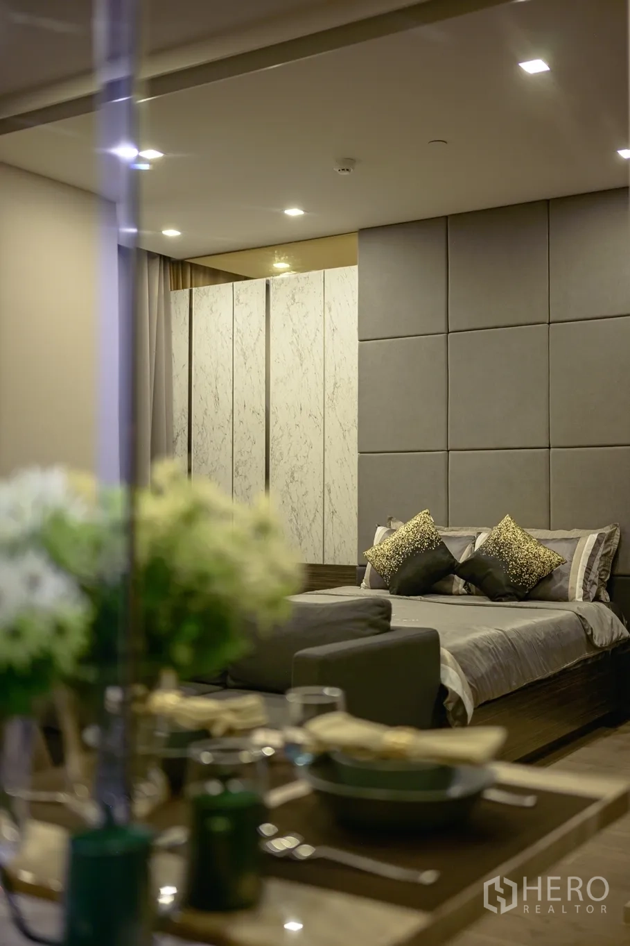 Condominium for rent in Watthana, Bangkok - Soft-focus flowers in the foreground framing the bed and feature wall.