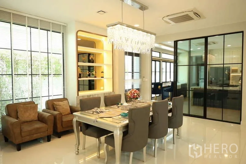 Detached House for rent or sale in Saphan Sung, Bangkok - Dining room with crystal pendant and sliding glass partition to kitchen.