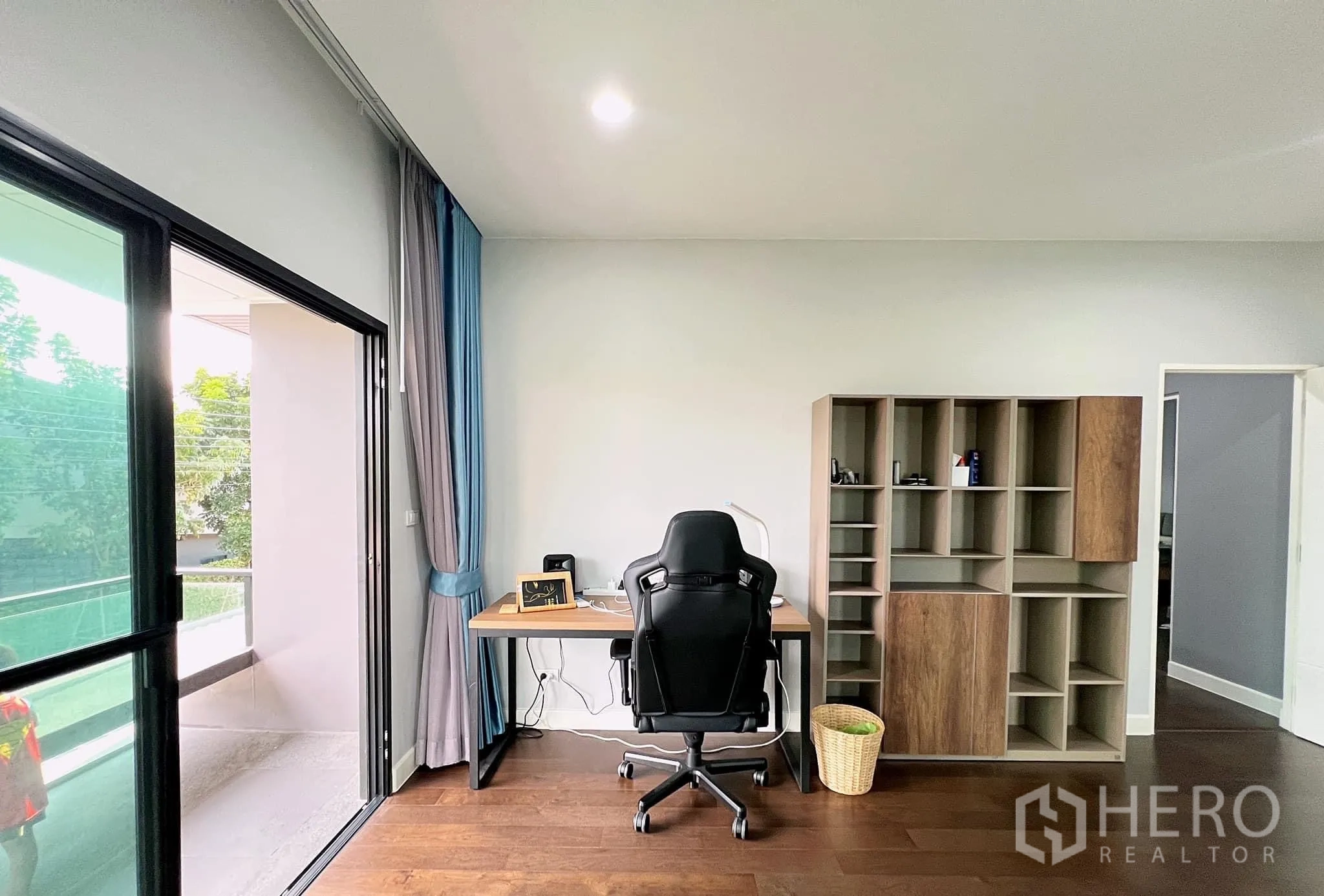 Detached House for rent or sale in Lam Luk Ka, Pathum Thani - Home office nook opening to balcony with built-in shelving.