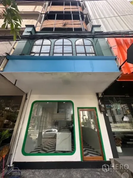 Shophouse for rent in Khlong Toei, Bangkok - Thonglor shophouse facade with arched second-floor windows and glass storefront.