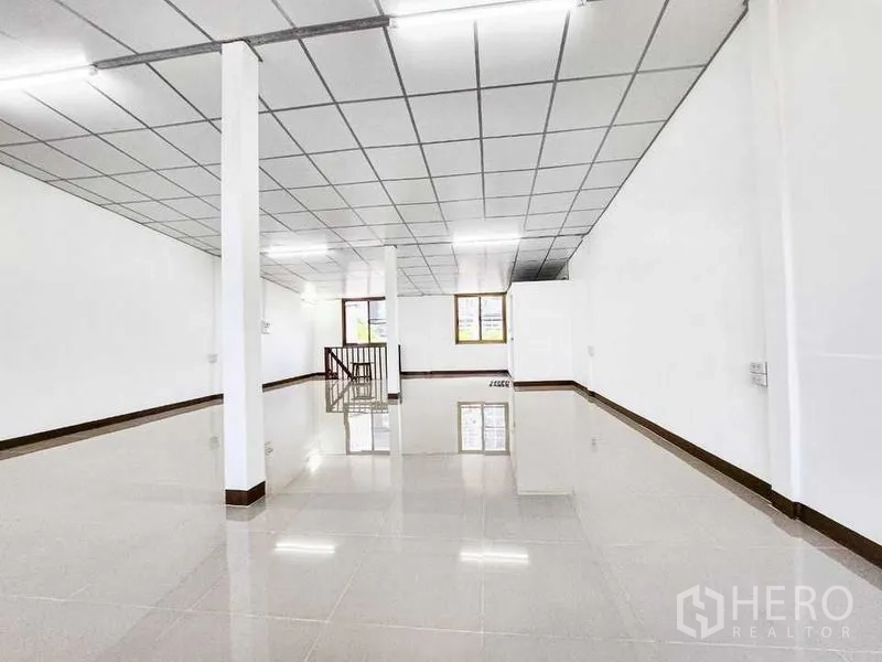 Home Office for rent in Khlong Toei, Bangkok - Large upper-floor workspace with drop ceiling, pillars and a central stairwell.