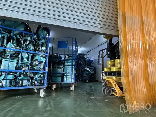工厂 出租在Lat Krabang, Bangkok - 冷库入口，卷闸门开启，可见网笼车与手动叉车，环氧地坪。