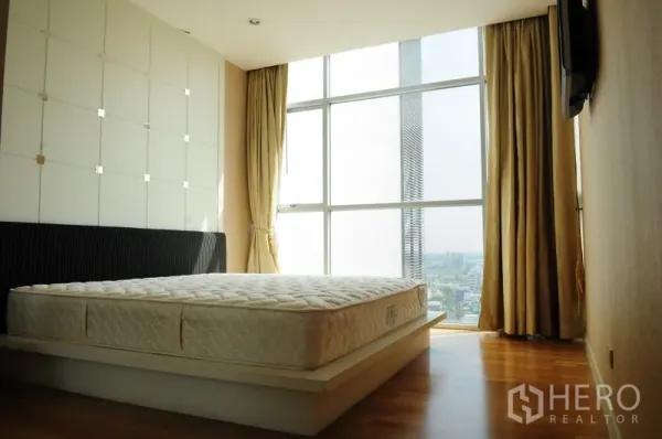 คอนโด ให้เช่าในPathum Wan, Bangkok - ห้องนอนสว่างด้วยกระจกสูงจรดเพดาน ม่านทึบ พื้นไม้ และวิวเมือง