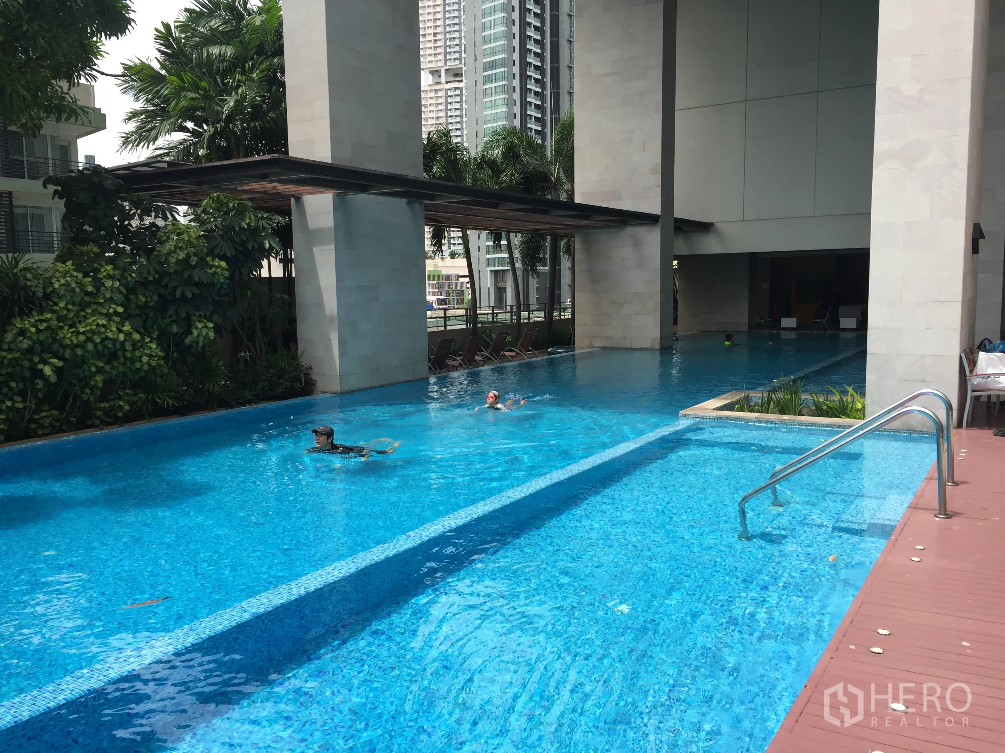 公寓 出租在Watthana, Bangkok - 公寓泳道泳池，设日光平台与热带绿植。