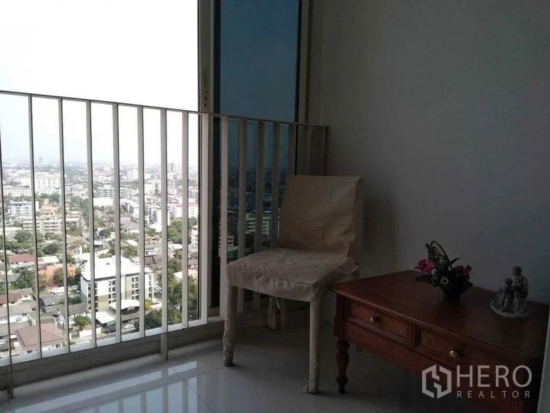 公寓 出租在Watthana, Bangkok - 阳台一角摆放椅子与边几，可观曼谷城市景观。