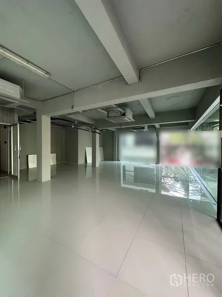 零售空间 出租在Bang Rak, Bangkok - 开放式零售空间，抛光白色瓷砖地面、外露吊顶管线与大窗。