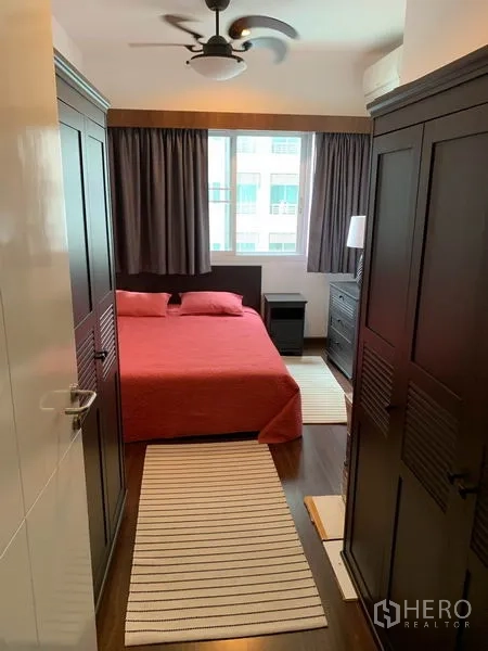 公寓 出租在Bang Kapi, Bangkok - 采光良好的卧室，大窗、吊扇、深色衣柜与红色床品。