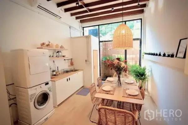 Office Space for rent in Sathon, Bangkok - Compact kitchen and dining space with washer, built-in cabinets and rattan pendant light.