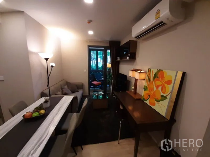 公寓 出租或出售在Watthana, Bangkok - 客厅面向阳台，设沙发、电视、层架与紧凑工作区。