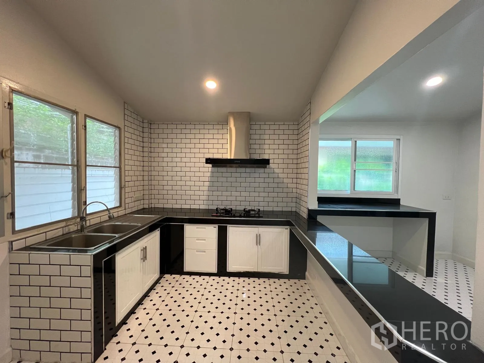 Detached House for rent in Saphan Sung, Bangkok - Fitted kitchen with white subway tiles, black countertops, gas hob, extractor and double sink.