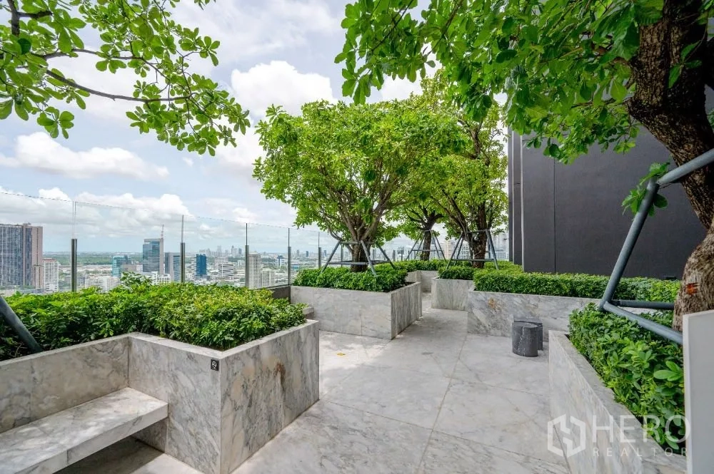 Condominium for rent or sale in Khlong Toei, Bangkok - Rooftop garden terrace with trees, hedges and panoramic Bangkok views.