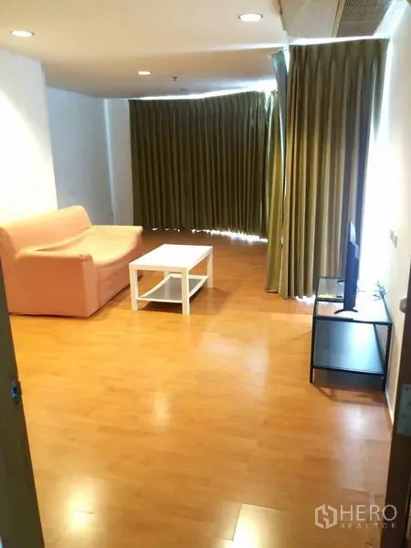 Condominium for rent in Watthana, Bangkok - Spacious living room with sofa, TV stand, recessed lighting and floor‑to‑ceiling curtains.