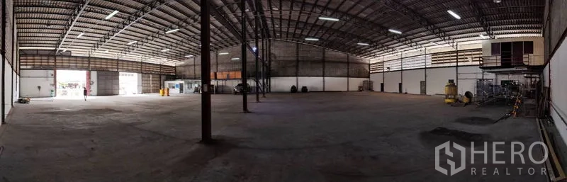 货栈 出租在Bang Phli, Samut Prakan - 大型仓储大厅，钢柱支撑，装卸门开启，顶灯明亮。