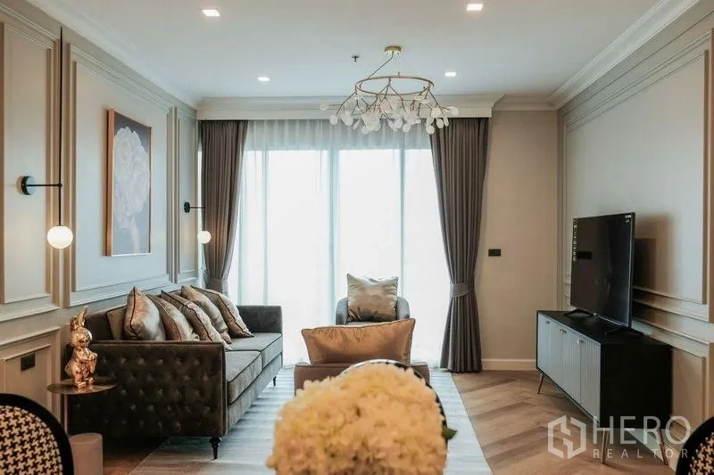Condominium for rent in Khlong Luang, Pathum Thani - Open-plan dining and living area with six-seat table, island kitchen and modern lighting.