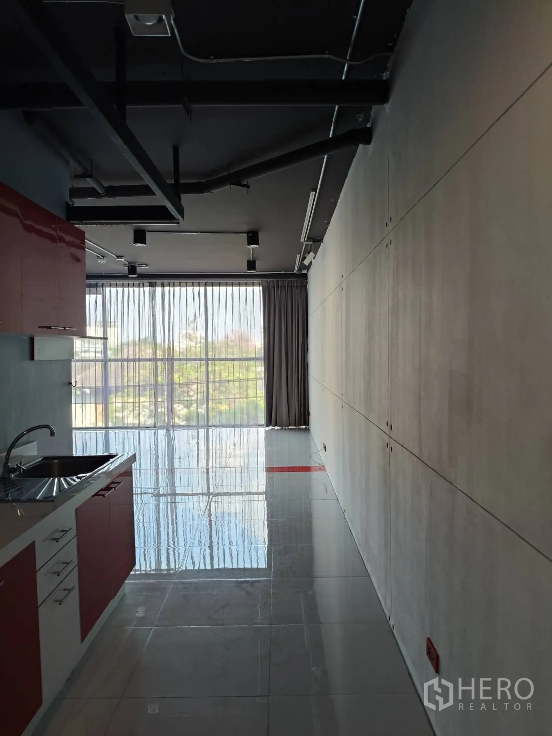 办公空间 出租在Khlong Toei, Bangkok - 从茶水间望向大窗与开放办公区，顶部可见管线与灯轨。