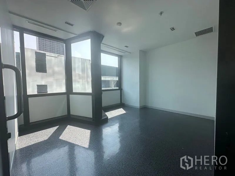 Office Space for rent in Khlong Toei, Bangkok - Corner office with wraparound windows and a structural pillar.