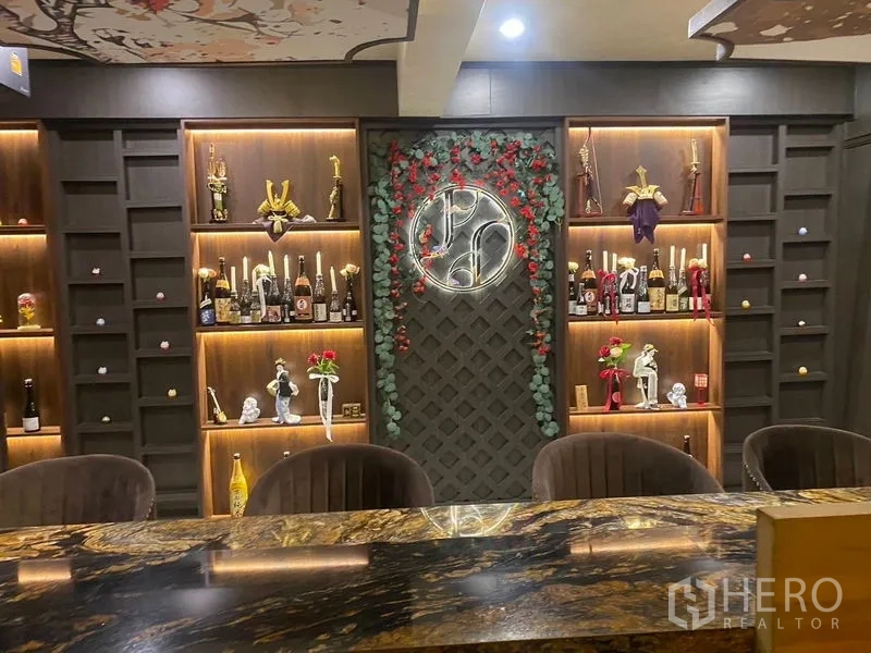 Shophouse for rent - Feature wall behind the bar with lit display niches and a circular neon sign.