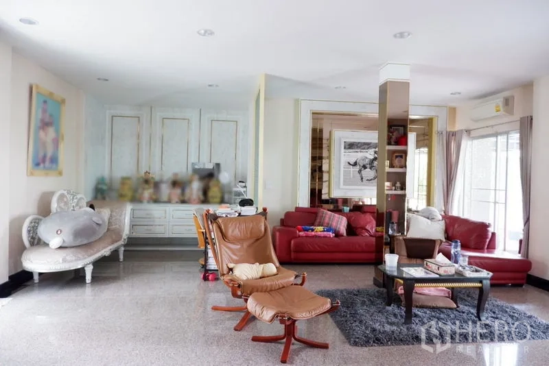 Detached House for sale in Saphan Sung, Bangkok - Spacious living room with red sofas, lounge chairs, large windows and glossy floors.