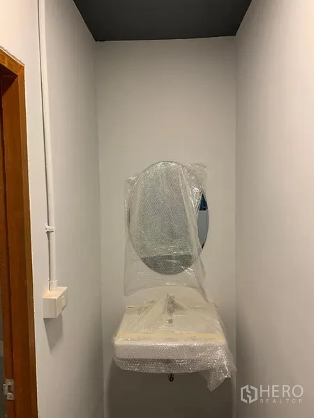 Shophouse for rent in Khlong Toei, Bangkok - Compact restroom area with new sink and mirror protected by bubble wrap, ready for installation.