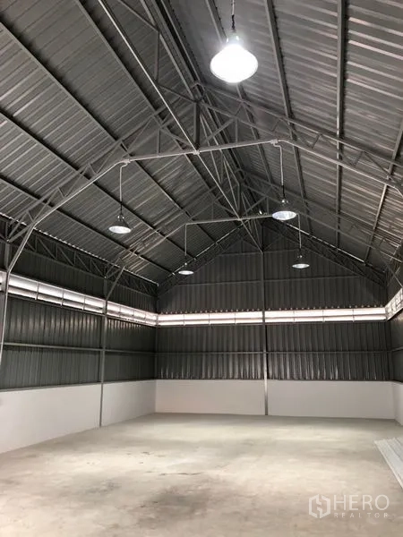 Warehouse for rent in Bueng Kum, Bangkok - Interior of high-ceiling warehouse showing steel trusses and bright high-bay lights